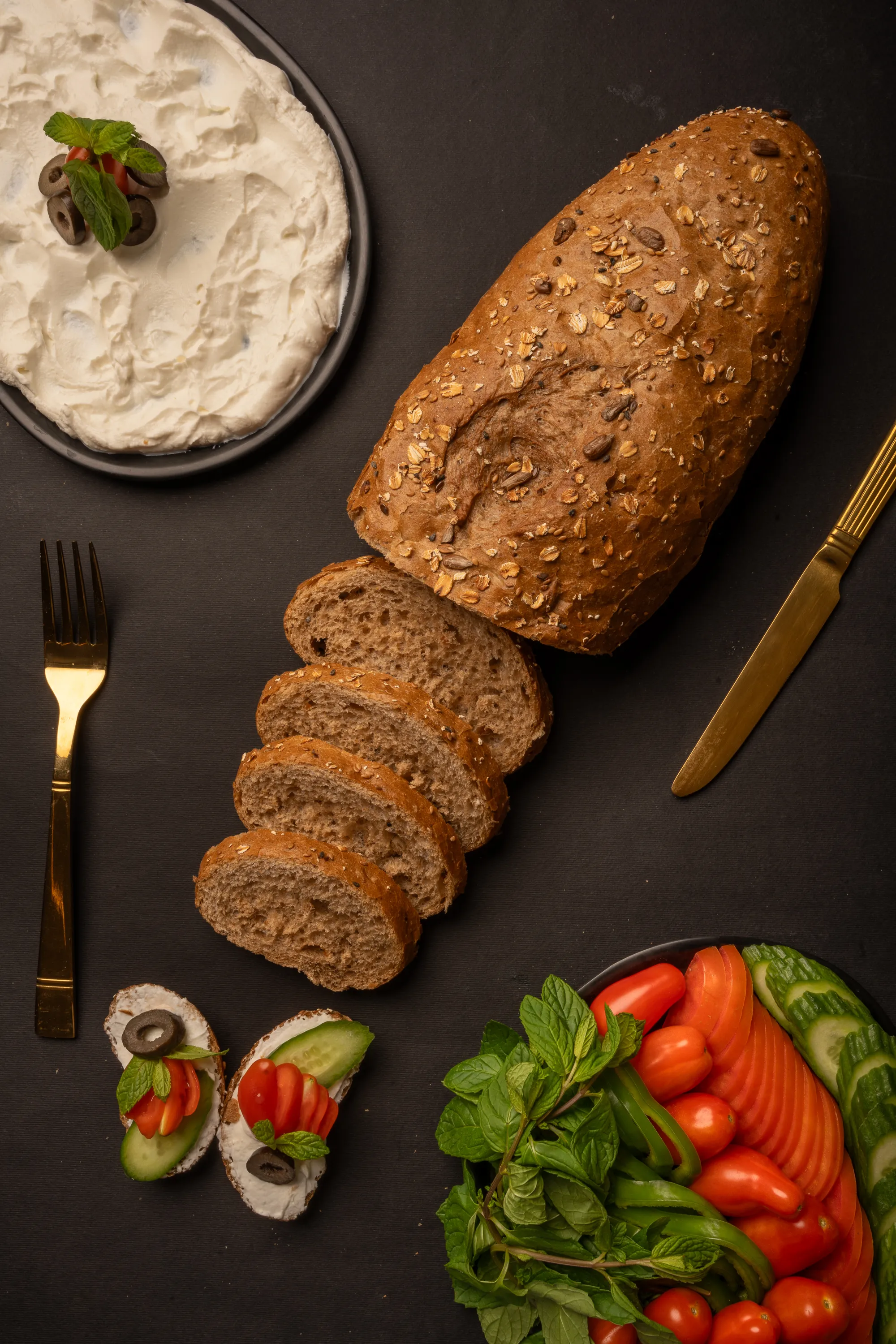 رغيف خبز أسمر طازج مع اللبنة والخضار